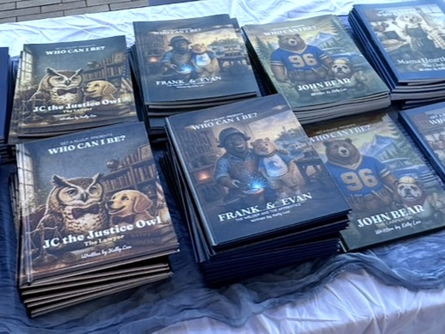 Stacks of Who Can I Be? books, including JC the Justice Owl, Frank and Evan and John Bear, on a display table
