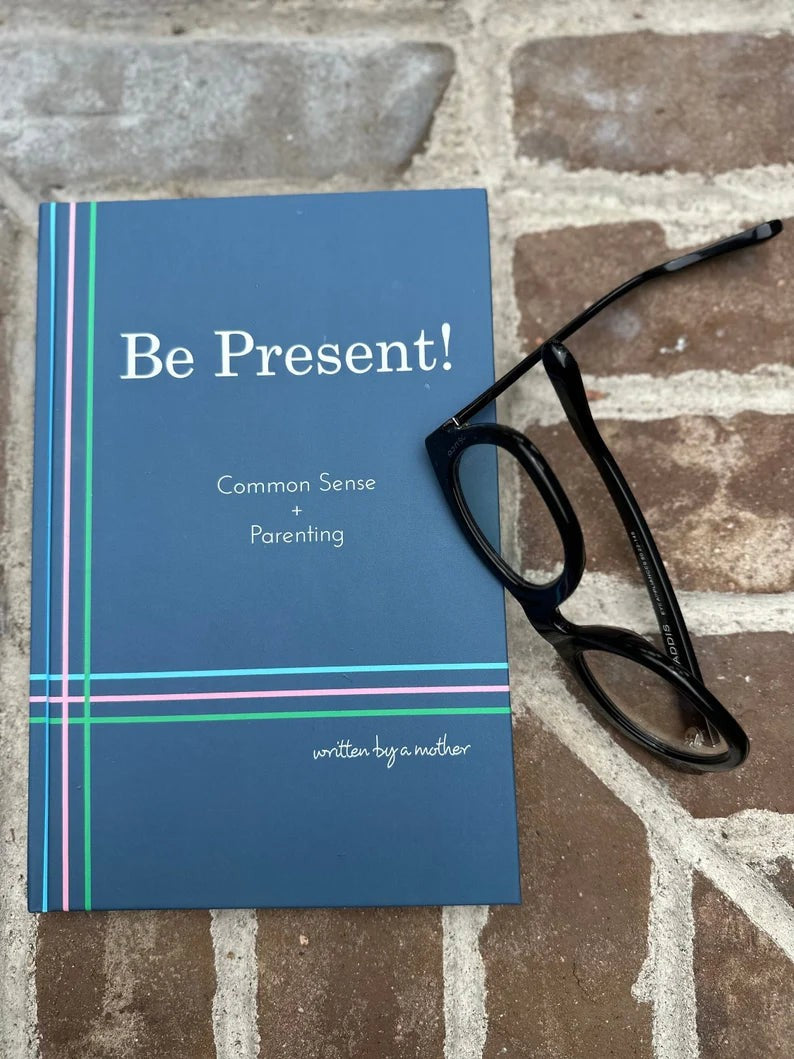 Be Present book cover lying on a brick surface next to a pair of reading glasses